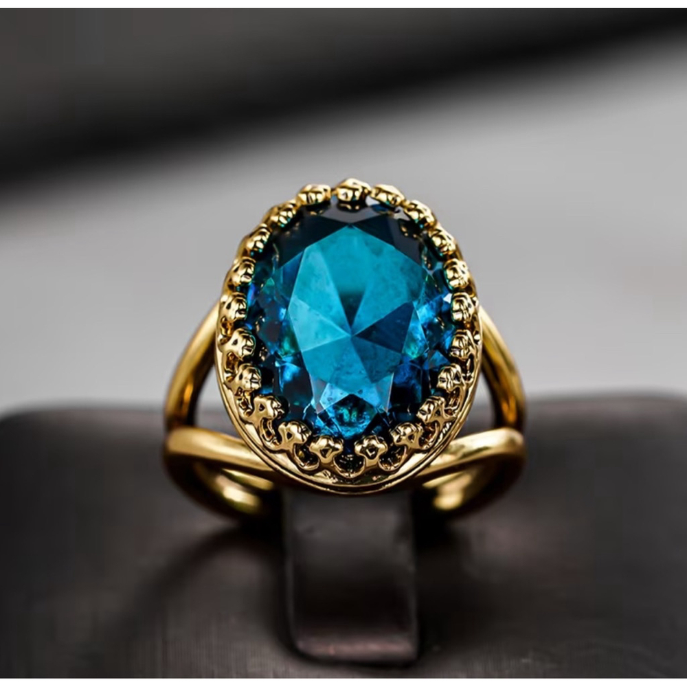 Vintage-Inspired Oval Blue Gemstone Ring in Gold with Ornate Bezel Setting